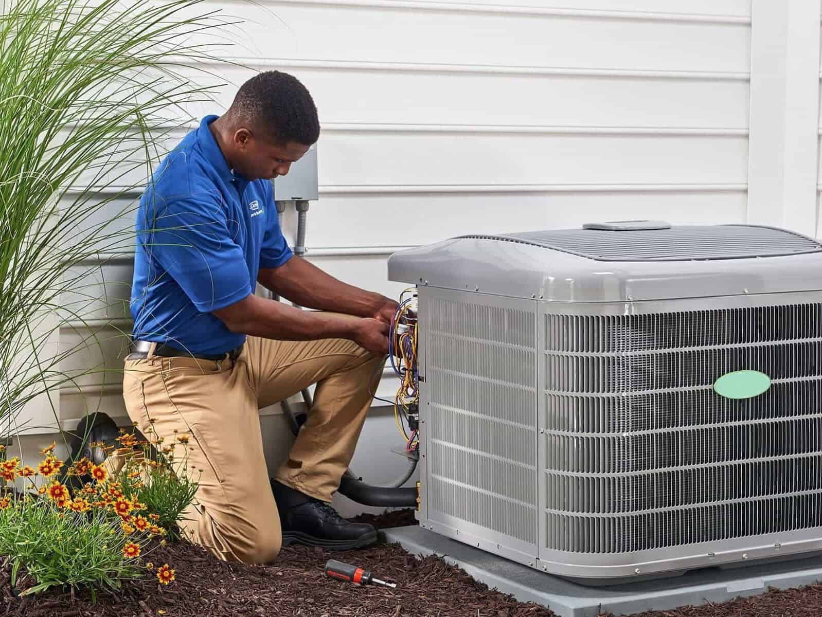 a technician uses a coil cleaner to clean a dirty air conditioning condenser coil next to a clean one, with the outdoor unit visible in the background. regular maintenance and cleaning can prevent energy consumption, reduced cooling capacity, and system breakdowns.