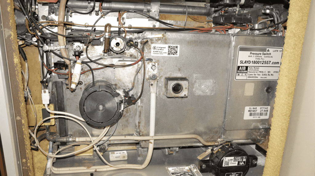 A close-up of an open furnace component showing detailed wiring connected to the pressure switch, highlighting areas for troubleshooting common furnace pressure switch problems.