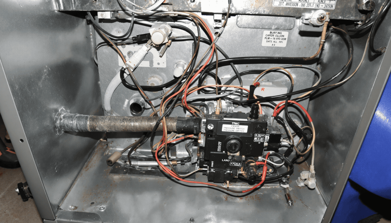 Close-up of a furnace interior showing detailed wiring and components, including the pressure switch. This image highlights key areas for diagnosing and fixing common furnace issues such as pressure switch failures.